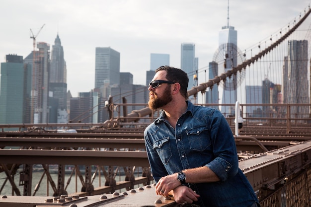 Erwachsener Mann steht auf der Brooklyn Bridge in der Stadt