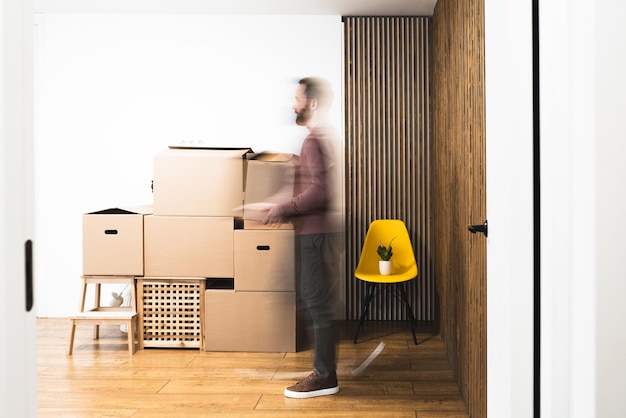 Erwachsener Mann zieht in eine neue Wohnung, neue Anfänge, Konzept, lange Belichtung.