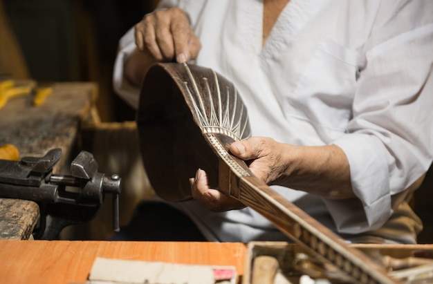 Erwachsener Meister restauriert alte Musikinstrumente. Herstellung von Saiteninstrumenten