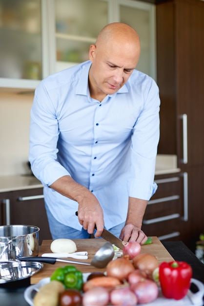 Foto erwachsener starker mann in der küche, die essen zubereitet