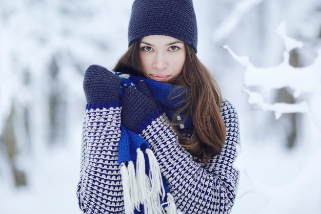 Erwachsenes Mädchen in einem Winterpark in Wollhandschuhen