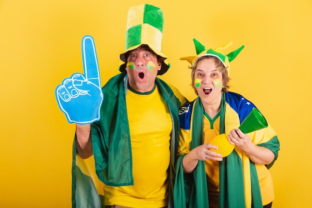 Erwachsenes paar fußballfan aus brasilien mit flagge und hut vibrieren wow unglaublich