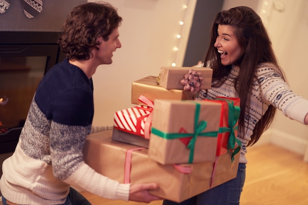 erwachsenes Paar mit Geschenk über Kamin