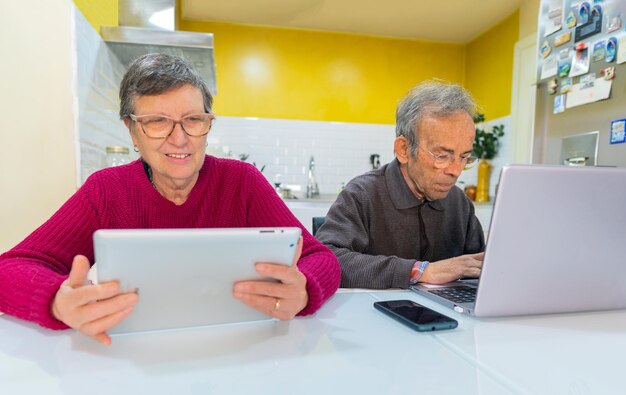 Erwachsenes Paar mit Tablet und Computer