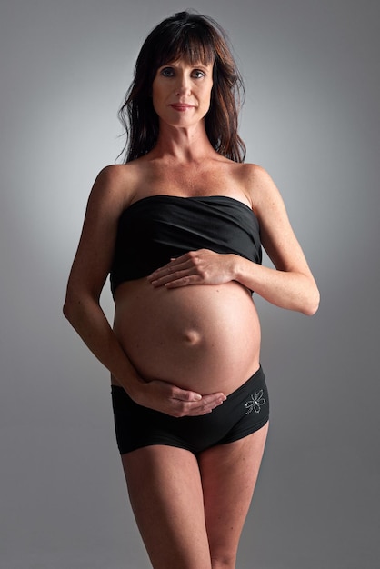 Erwartet ihre baldige Ankunft Eine schwangere Frau, die ihren Bauch hält