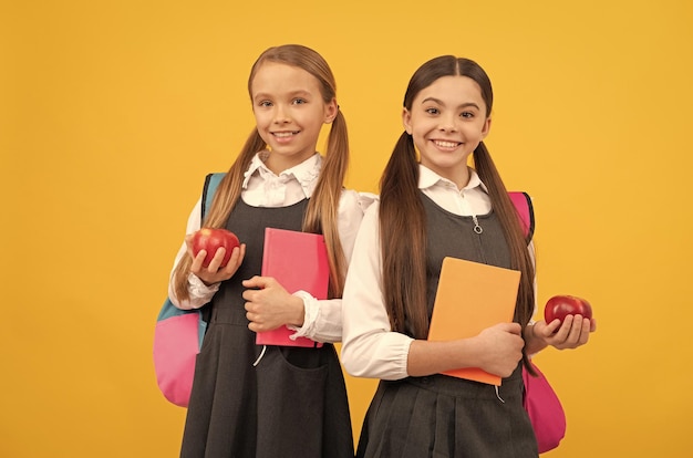 Erweiterung des Wissens über gesunde Ernährung Kinder halten Bücher und Äpfel in der Hand Nahrhafte Ernährung in der Schule