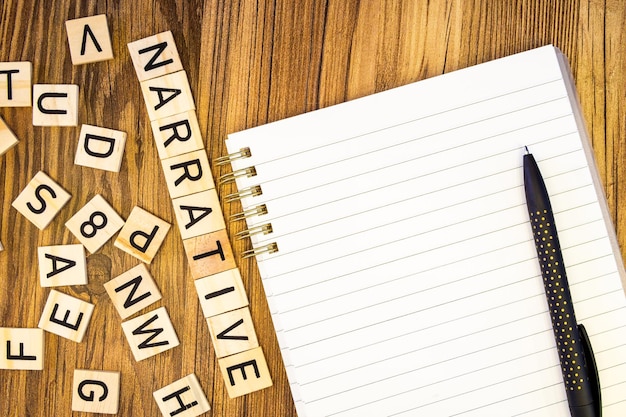 Foto erzählendes flaches lay aus lasergravierten buchstaben auf leeren zeilen notizbuch und stift mit verstreuten let