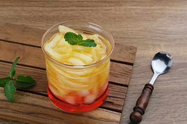 Es Blewah oder enthält Cantaloupe-Scheiben mit Sirup, die im Glas auf einem Holztisch serviert werden