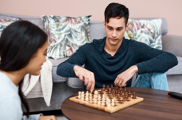 Es braucht ein Team, um die Quarantäne zu überstehen Aufnahme eines jungen Paares, das zu Hause eine Partie Schach spielt