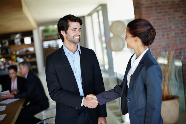 Foto es bueno conocerte finalmente un hombre de negocios sonriente estrechando la mano de un cliente