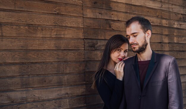 Esta es una chica enamorada con un chico posando sobre un fondo de madera feliz día de san valentín verano