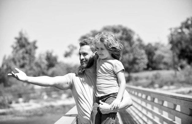 Es una crianza realmente maravillosa El padre feliz señala con el dedo a su hijo en brazos Crianza monoparental