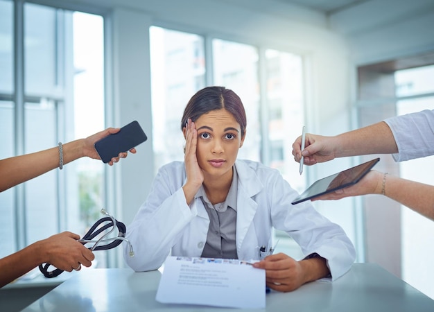 Es demasiado caótico para hacerle frente Retrato de una joven doctora que parece estresada en un entorno de trabajo exigente