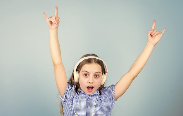 Es una estrella de rock Niño pequeño mostrando un gesto de la mano de cuerno como un fanático de hard rock o heavy metal Niño pequeño lindo escuchando música rock tocando en auriculares Niña adorable disfrutando de música punk rock