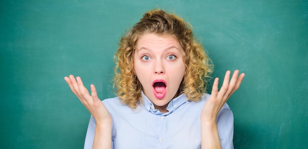 Esta es una estudiante increíblemente sorprendida en la maestra de la pizarra en la lección de la escuela día del conocimiento información de la pizarra vacía de regreso a la escuela A la niña le gusta estudiar la educación de la tarea el 1 de septiembre