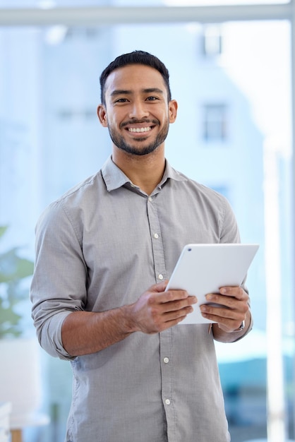 Es gibt immer eine App, die meine Arbeit erleichtert Porträt eines jungen Geschäftsmanns, der ein digitales Tablet in einem Büro verwendet