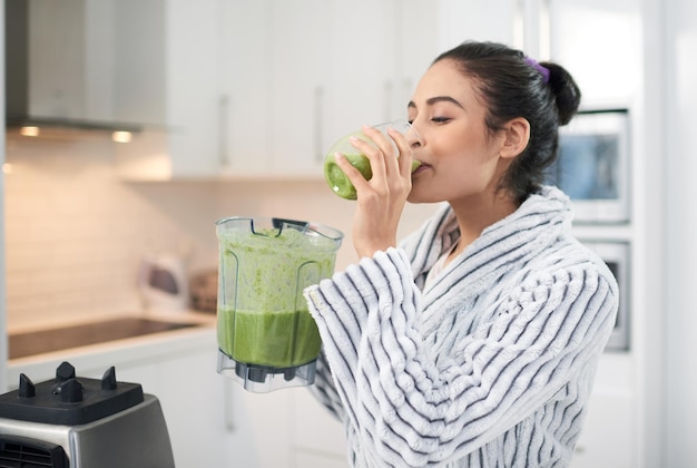 Es gibt keinen besseren Start in den Tag Schnappschuss einer Frau, die zu Hause einen Smoothie trinkt