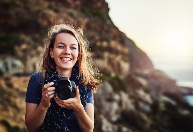 Foto es gibt so viel zu entdecken und festzuhalten auf der welt porträt einer jungen frau, die mit ihrer kamera im freien fotografiert