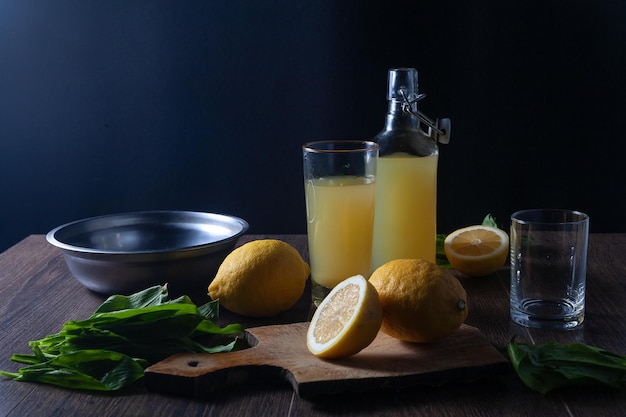 Es gibt Zitronensaft in einer Flasche und ein Glas auf dem Tisch Zurückhaltend