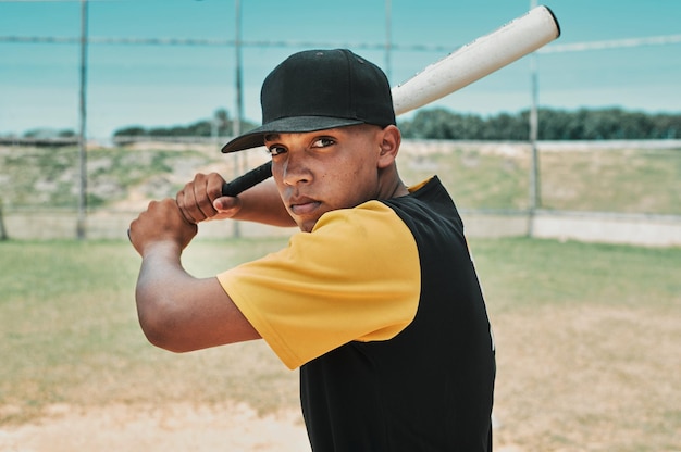 Es hora de golpear fuerte y correr rápido Toma de un joven jugador de béisbol sosteniendo un bate de béisbol mientras posa afuera en el campo