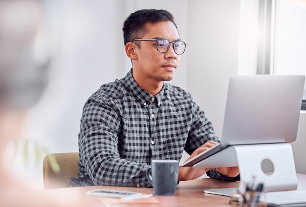 Es hora de trabajar Foto de un joven empresario usando una computadora portátil en una oficina