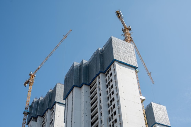 Es ist ein schöner Tag mit blauem Himmel und der Turmdrehkran auf den Hochhäusern in der Stadt ist im Bau