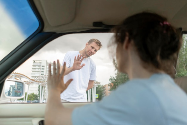 Foto es ist zeit, sich von einem traurigen mann zu verabschieden, der mit der hand winkt und seinen freund verlässt