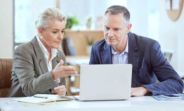 Esto es con lo que estábamos trabajando Toma de dos empresarios usando una computadora portátil juntos en una oficina en el trabajo