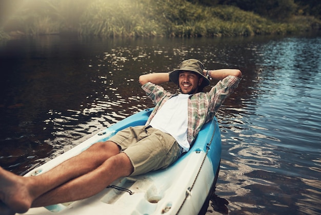 Es más feliz cuando está flotando en el lago Retrato de un joven disfrutando de un paseo en canoa por el lago