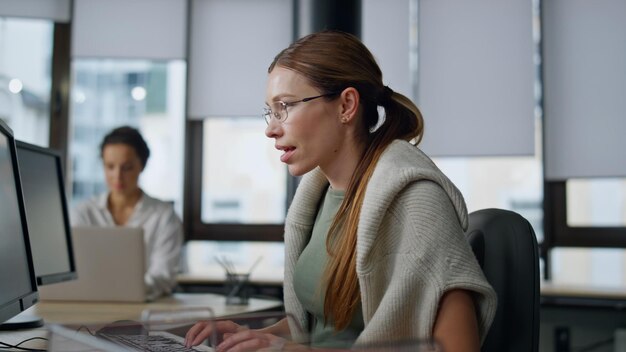 Es una mujer programando código en la oficina desarrolladora de software casual escribiendo computadora