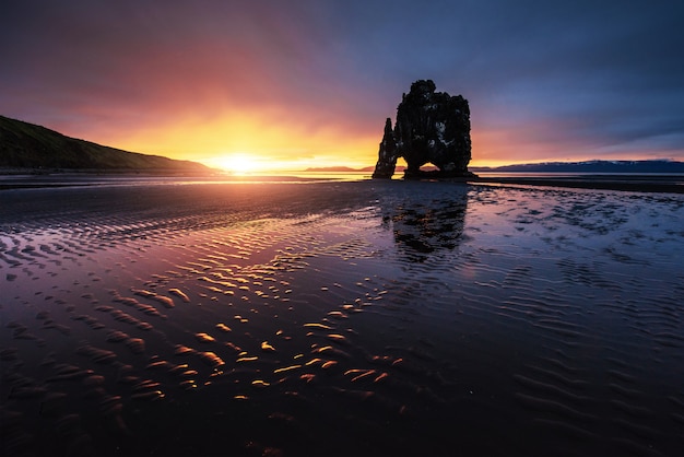 Es una roca espectacular en el mar en la costa norte de Islandia. Las leyendas dicen que es un troll petrificado. En este Hvitserkur se refleja en el agua del mar después del atardecer de medianoche.