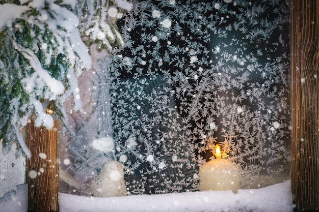 Es una tarde de invierno, está nevando y hay una vela en la ventana.