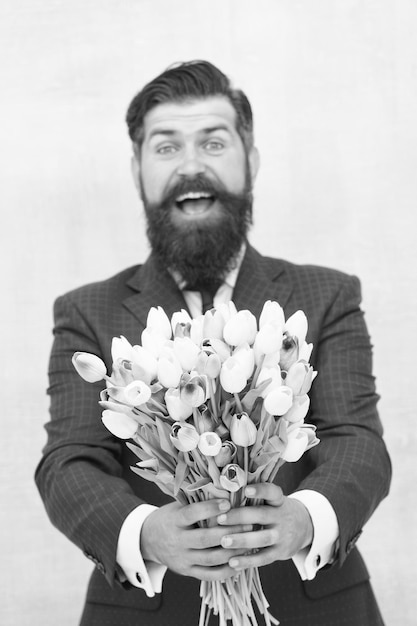 Esto es para ti Se acerca la primavera Saludos Ramo de tulipanes de hombre barbudo Día de la mujer 8 de marzo Regalo de primavera Hipster de hombre barbudo con flores Celebra la primavera Haciendo sorpresa Caballero con tulipanes