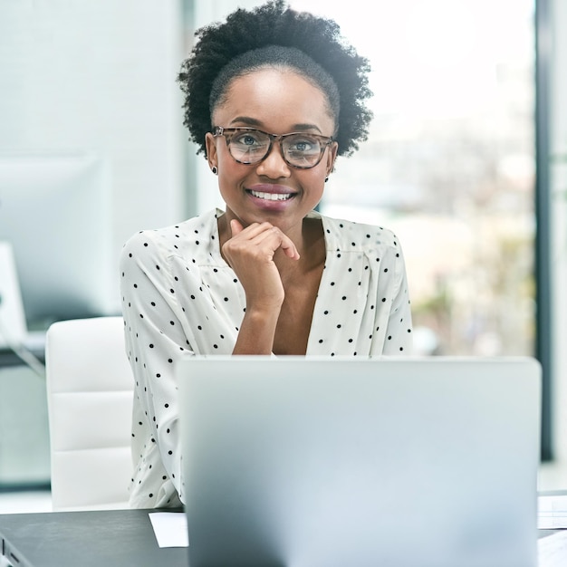 Es un trabajo que puedo hacer con una sonrisa Retrato recortado de una joven empresaria que trabaja en su escritorio en la oficina