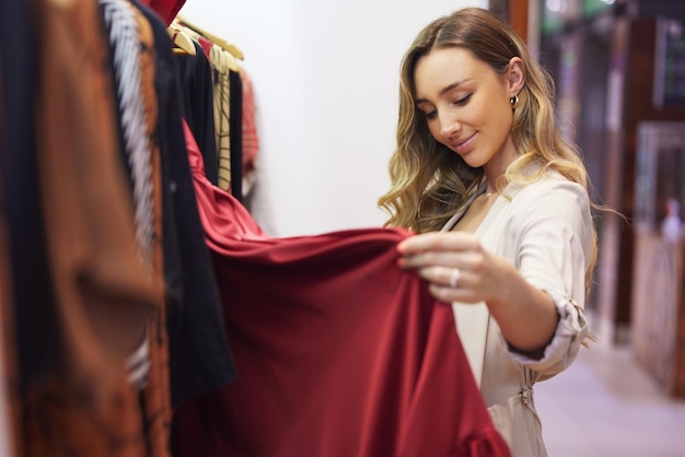 Este es el vestido perfecto Fotografía de una mujer joven hojeando algo de ropa