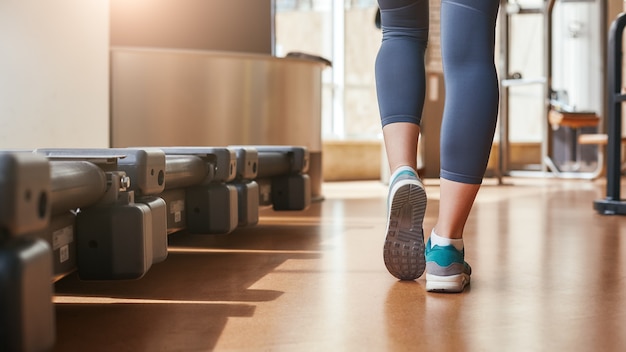 Es war eine großartige Rückenansicht der Frauenbeine in Leggings und blauen Turnschuhen zu Fuß?