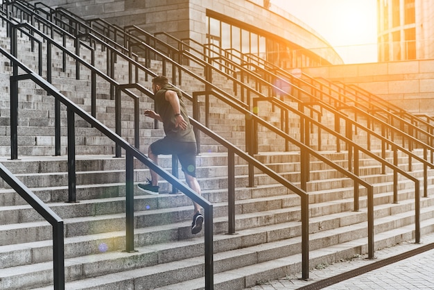 Es wird hart gedrängt, um zu gewinnen. junger Mann in Sportkleidung läuft die Treppe hoch