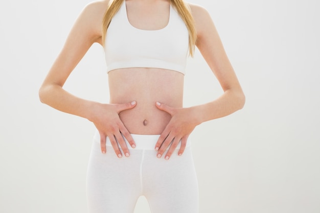 Esbelta mulher esportiva tocando sua barriga