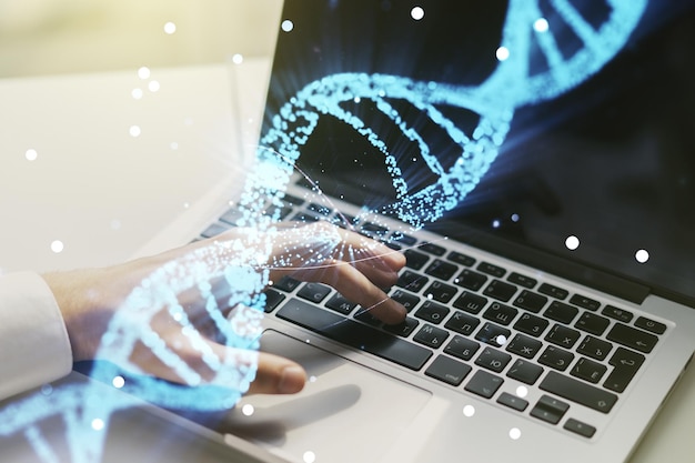 Esbozo creativo de ADN y manos escribiendo en el teclado de la computadora sobre biotecnología de fondo y concepto genético Multiexposición