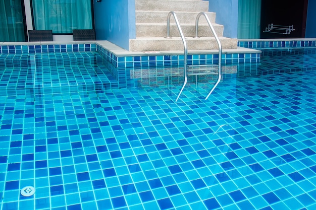 Escada da piscina com água azul