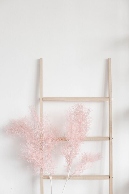 Escada de madeira decorativa com flor rosa artificial em estilo minimalista