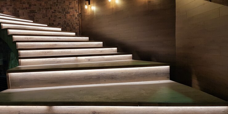 Escada iluminada com degraus de madeira e iluminada à noite no interior de uma grande casa