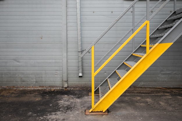 Escada metálica pintada de amarelo no armazém da fábrica