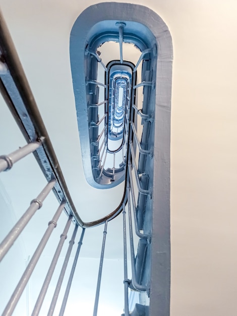 Escadaria em espiral azul em Paris. Entrada na França com uma escada azul centáurea. Vista de baixo.