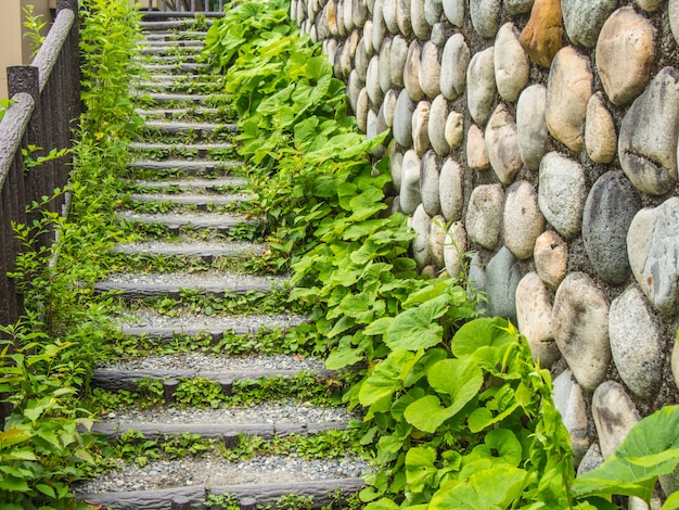 Escadas feitas de pedras com plantas e paredes de pedra nas laterais.