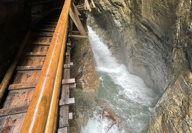 Escadas íngremes ao longo de cachoeira e pedras na Áustria