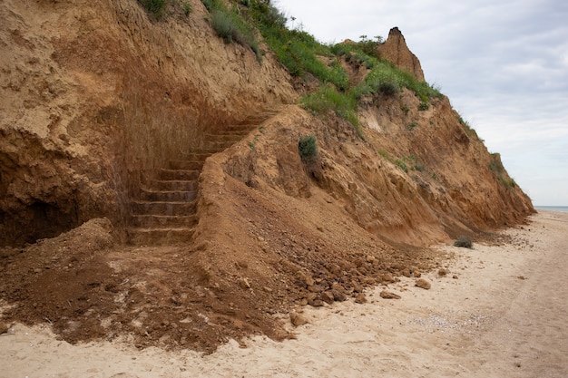 Escadas na falésia, praia e litoral com falésia íngreme