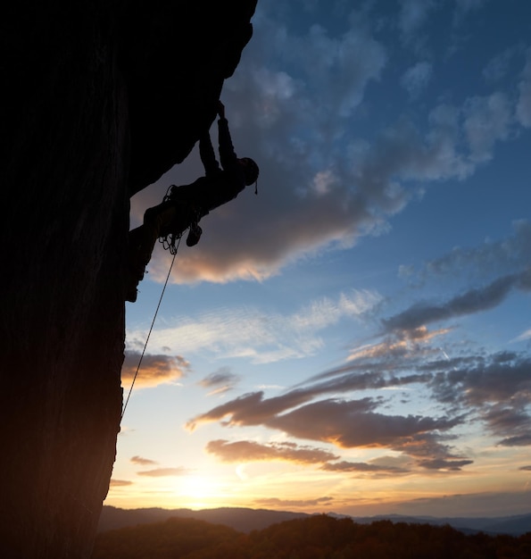 Escalada de silhueta atlética Céu do nascer do sol com nuvens Copiar espaço Vista lateral Conceito de realizações líderes de sucesso