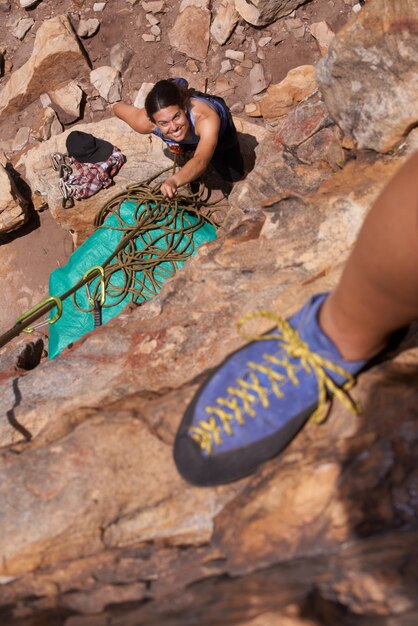 Foto escalada de montañas y naturaleza con pov borde y cuerda para ejercicio y aventura con amigos mujeres fitness y peligro con equipo riesgo y emoción en la cornisa con equipo y pasatiempo al aire libre