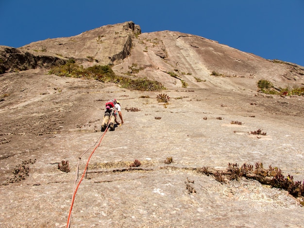 Escalador escalando una pared de roca inclinada en Brasil